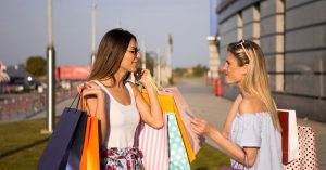 Zwei Frauen sind nach dem Shopping mit Einkaufstüten beladen
